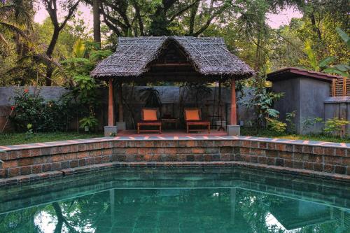 a swimming pool with a gazebo and a house at Chittoor Kottaram Royal Mansion- CGH Earth in Cochin