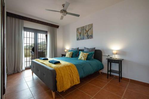 a bedroom with a bed and a ceiling fan at Villa Mantequilla in Alora