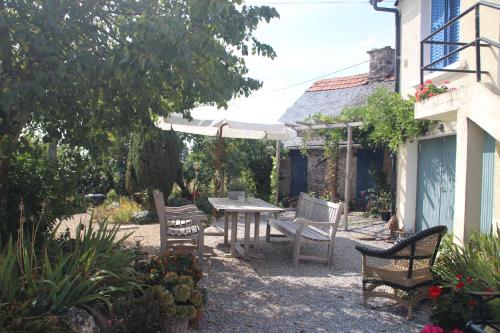 a patio with a table and chairs and an umbrella at Apartment Fleur de Lys Bleue in Soudaine-Lavinadière