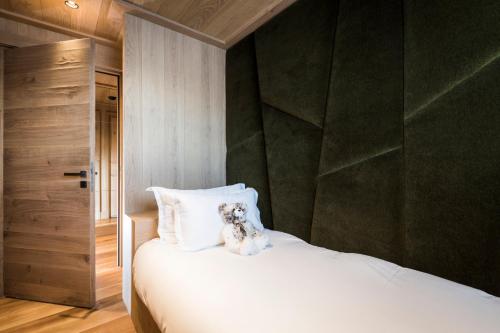 a dog sitting on top of a white bed at Armancette - The Leading Hotels of the World in Saint-Gervais-les-Bains