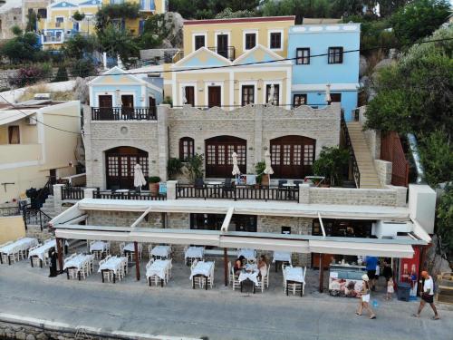 a building with tables and chairs in front of it at Odyssia in Symi