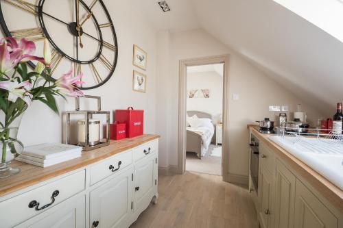 a kitchen with a large clock on the wall at The Loft in Calne