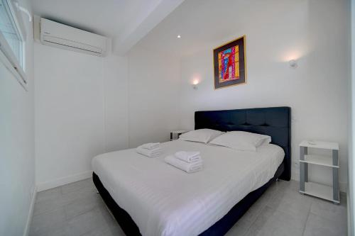 - une chambre dotée d'un grand lit avec des draps blancs et des oreillers blancs dans l'établissement IMMOGROOM - Panoramic View - quiet - AC - bright, à Cannes