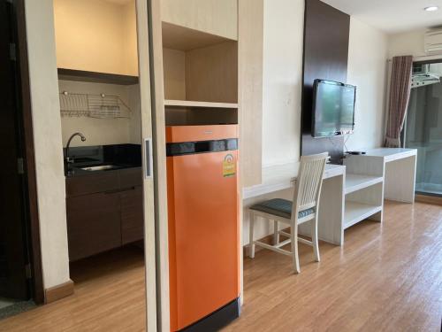 an orange refrigerator in a kitchen with a desk at Teddy@Thammasart in Pathum Thani