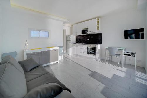 sala de estar blanca con sofá y cocina en IMMOGROOM - Panoramic View - quiet - AC - bright, en Cannes