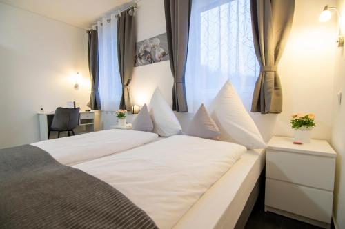 Un dormitorio con una gran cama blanca y una ventana en Hotel L201 - 24h self-check in en Gablitz
