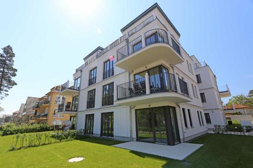 a large white building with a lawn in front of it at Strandvilla Andrea Whg 02 MeerZeit mit Terrasse in Baabe