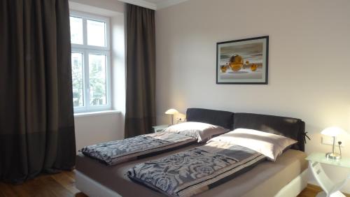 Bett in einem Schlafzimmer mit Fenster in der Unterkunft Sonnberg Design Apartments in Wien