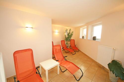 Zimmer mit orangefarbenen Stühlen, einem Tisch und einem Fenster in der Unterkunft Grüne Düne Whg 21 - Meerblick in Baabe
