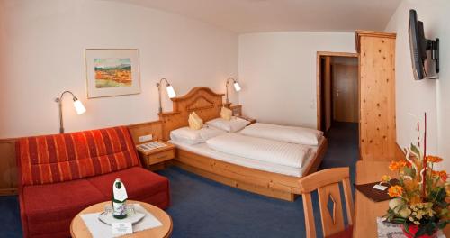 a hotel room with a bed and a couch at Hotel Wagner in Obertauern