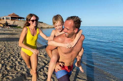 um homem e duas mulheres brincando na praia em Three Corners Equinox Beach Resort em Abu Dabbab