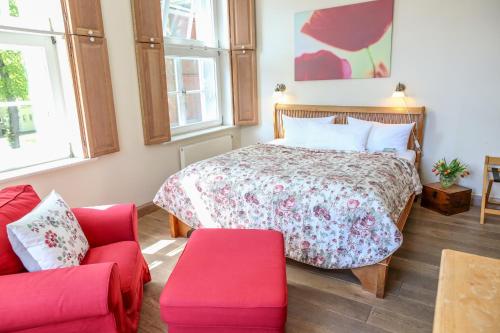 a bedroom with a bed and a couch at Altstadthotel Twardokus in Aurich