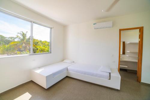 a white room with a bed and a window at Quinta del Mar La Joya in Tolú
