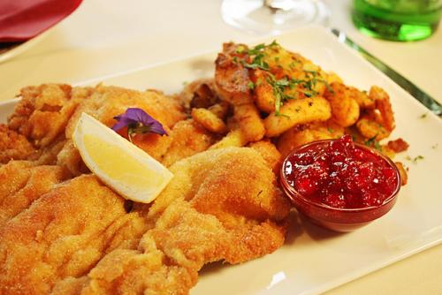 a plate of food with shrimp and a lemon slice at Boutique-Pension Jägerwirt in Scheffau am Wilden Kaiser