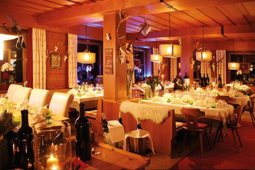 a dining room with tables and chairs with wine bottles at Boutique-Pension Jägerwirt in Scheffau am Wilden Kaiser
