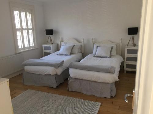 ein Schlafzimmer mit zwei Betten und einem Fenster in der Unterkunft Strandview Ground Floor Beach Apartment in Ballycastle