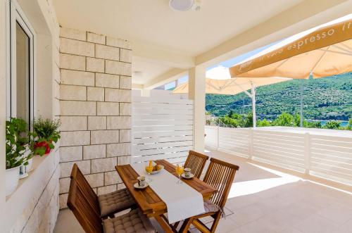 a patio with a table and chairs and an umbrella at Apartment Moon River in Mokošica