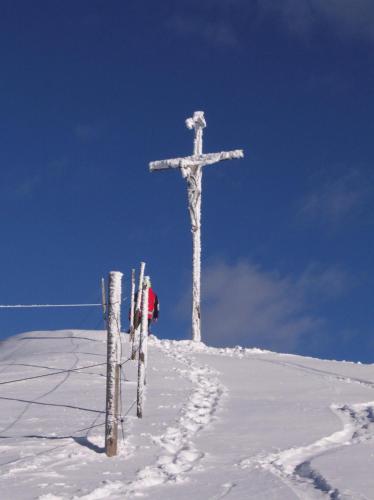 a cross on top of a snow covered hill with skis at Villa Hubertus in Ortisei