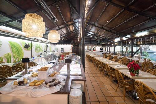 a restaurant with tables and chairs with food on them at Hotel Arena Suite - Adults Only in Corralejo