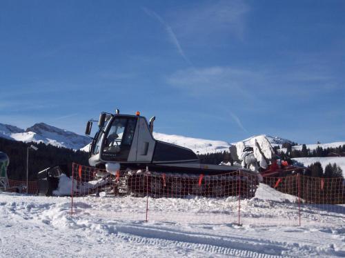 a bulldozer parked in the snow in front of a mountain at Villa Hubertus in Ortisei