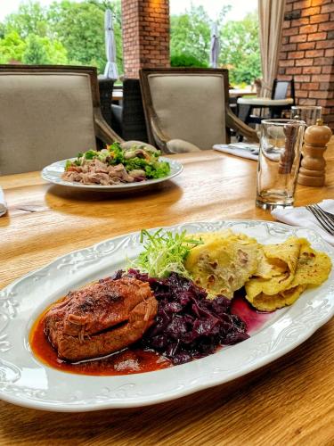 a table with two plates of food on it at Park Hotel Popovicky in Popovičky