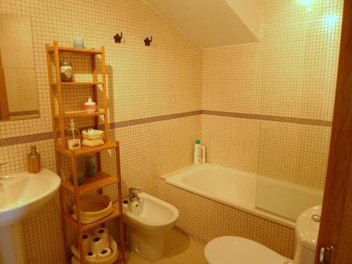 a bathroom with a tub and a toilet and a sink at Apartamento en Nueva de Llanes in Nueva de Llanes
