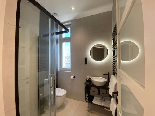 a bathroom with a shower and a toilet and a sink at Chevron Hotel in Prague