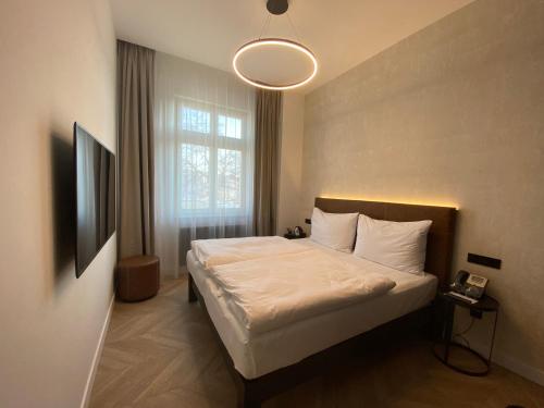 um quarto com uma cama e uma grande janela em Chevron Hotel em Praga