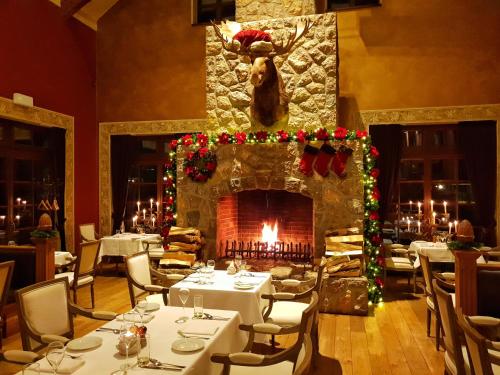 a dining room with a fireplace and tables with christmas decorations at Park Hotel Popovicky in Popovičky