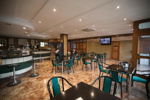 restauracja ze stołami i krzesłami oraz bar w obiekcie Hotel Odon w mieście Cocentaina