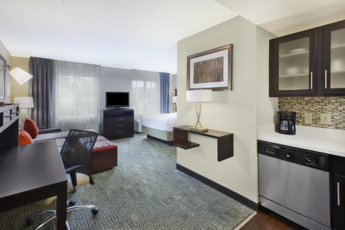 Mayfield HeightsにあるStaybridge Suites Cleveland Mayfield Heights Beachwood by IHGのベッドと机があるホテルの部屋