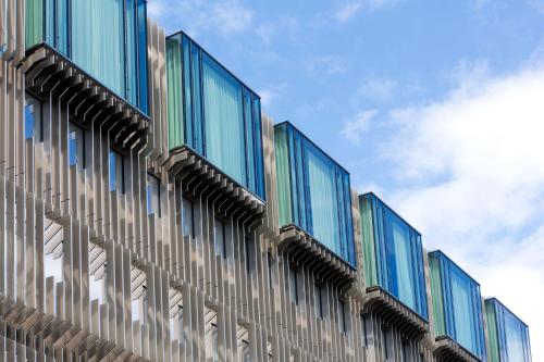 a building with glass windows on the side of it at Hotel L'Arbre Voyageur - LILLE in Lille