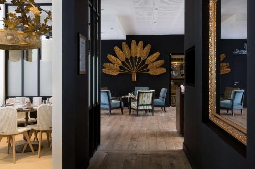 a dining room with a mirror and chairs at Hotel L'Arbre Voyageur - LILLE in Lille