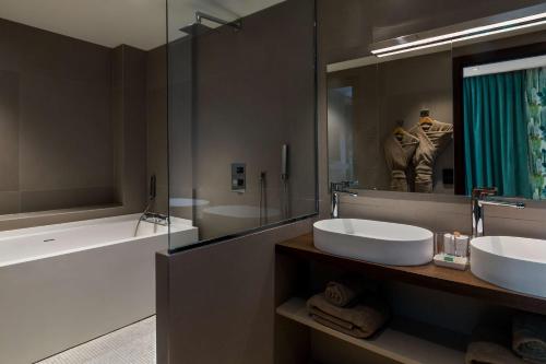 a bathroom with two sinks and a large mirror at Hotel L'Arbre Voyageur - LILLE in Lille