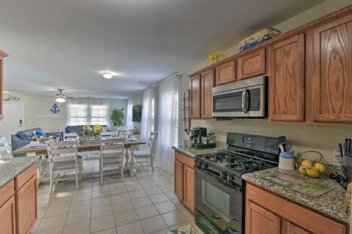 a kitchen with wooden cabinets and a kitchen with a table at Galloping Seahorse Seabrook Home about 4 Mi to NASA! in Seabrook