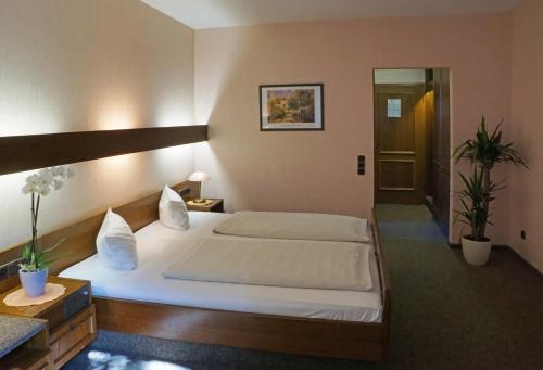 a bedroom with a large white bed in a room at Hotel Zur Heide in Aachen