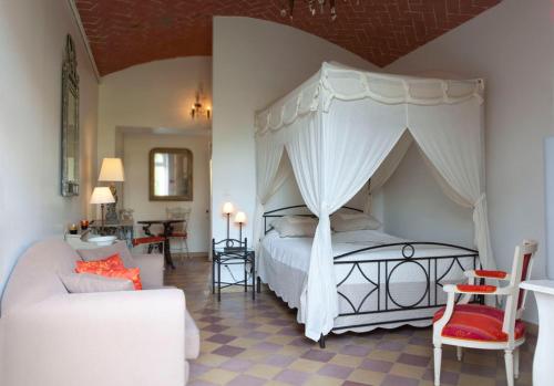 a bedroom with a canopy bed and a living room at La Bretauche in Chécy