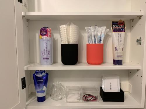 a shelf with toothbrushes and other items on it at GUEST HOUSE APPLE in Osaka