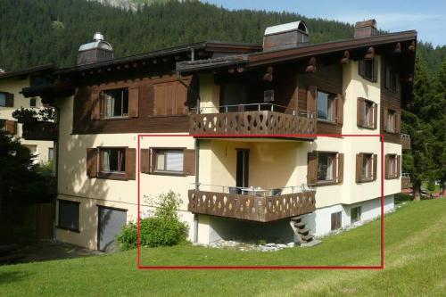 - un grand bâtiment avec un balcon sur le côté dans l'établissement Appartement in Hus Signal met prachtig uitzicht op de bergen, à Klosters Serneus