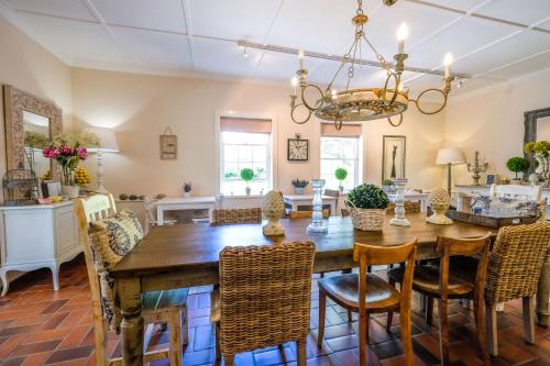 a dining room with a wooden table and chairs at Oude Berg Guesthouse - 10 Caledon Street in George