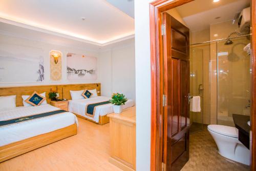 a hotel room with two beds and a bathroom at Melissa Hotel in Ninh Binh