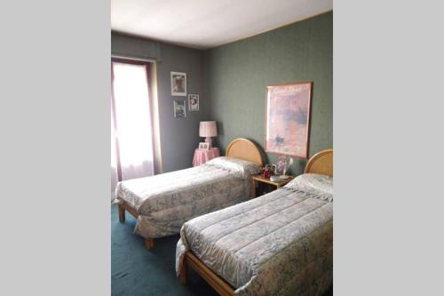 sypialnia z dwoma łóżkami i oknem w obiekcie La casa dei nonni (centralissimo trilocale) w mieście Bardonecchia