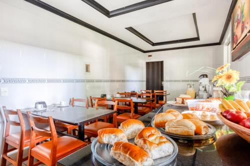 a bakery with a bunch of bread and tables and chairs at Ouro Hotel in Vespasiano