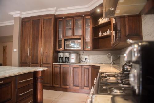 a kitchen with wooden cabinets and a stove at Potch Manor Boutique Guest House in Potchefstroom