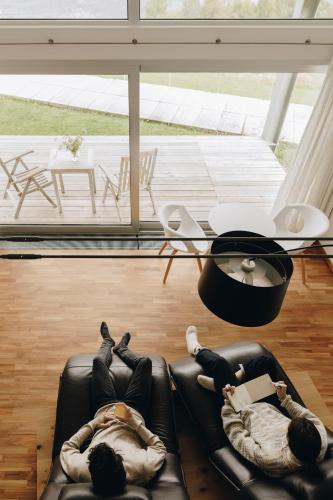 two people laying on a couch in a living room at Nebesa Chalets in Kobarid