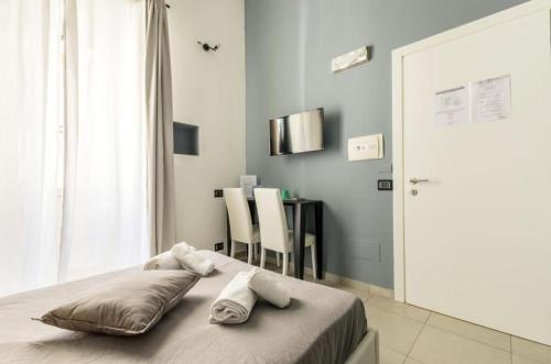 羅馬的住宿－Merulana 139 Suites，一间卧室配有一张床和一张桌子及椅子