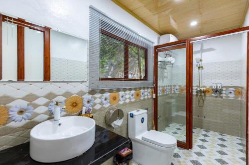 een badkamer met een wastafel, een toilet en een douche bij Trang An River View Homestay in Ninh Binh