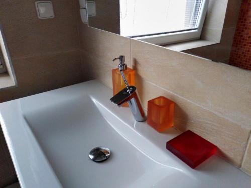 a sink with a faucet and an orange container on it at CHALUPA OSTRAVICE in Ostravice