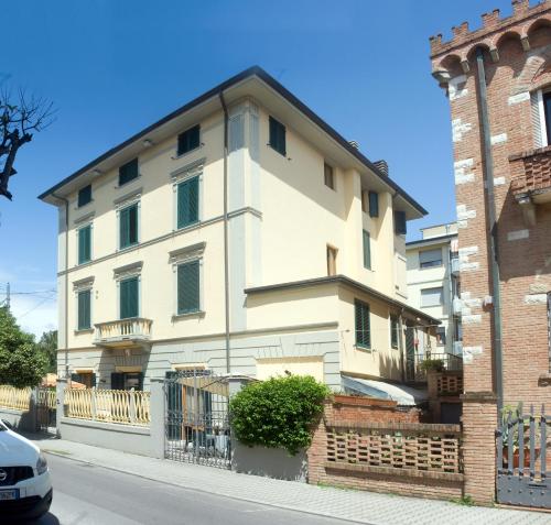 a large white house with a fence in front of it at Hotel Vittoria in Viareggio