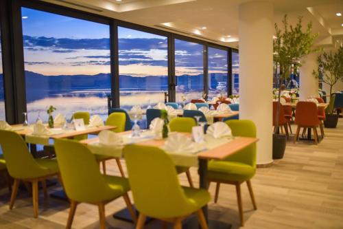 un restaurant avec des tables et des chaises et une grande fenêtre dans l'établissement Hotel Senad od Bosne, à Prokosovići